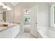 Bathroom featuring double sinks, bathtub, tile flooring, and door to main bedroom at 75 Fox Chase, Covington, GA 30016