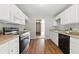 Well-equipped kitchen with white cabinets, stainless steel appliances, and attractive laminate flooring at 75 Fox Chase, Covington, GA 30016