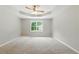 Spacious main bedroom featuring tray ceilings, ceiling fan and a large window at 75 Fox Chase, Covington, GA 30016