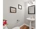 Stylish powder room with a pedestal sink, framed mirror, and wood-look laminate flooring at 75 Fox Chase, Covington, GA 30016