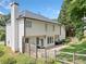 Back exterior shows a white two-story home, patio and landscaped lawn with trees at 2019 Aldbury Ln, Woodstock, GA 30189