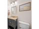 This well-lit bathroom offers vanity with granite countertop, framed mirror, and decorative light fixture above the sink at 2019 Aldbury Ln, Woodstock, GA 30189