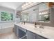 Spacious bathroom with a double sink vanity, a soaking tub, a large mirror, and large windows with wooded views at 2019 Aldbury Ln, Woodstock, GA 30189