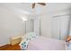Cozy bedroom with hardwood floors, a ceiling fan, white walls, and a comfortable bed, illuminated by natural light at 2019 Aldbury Ln, Woodstock, GA 30189