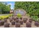 An inviting community entrance sign with American flags, flowers, and manicured bushes welcomes residents and guests at 2019 Aldbury Ln, Woodstock, GA 30189