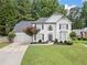 Charming traditional home featuring a manicured lawn, three-car garage, and lush landscaping at 2019 Aldbury Ln, Woodstock, GA 30189