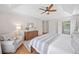Bright primary bedroom boasts hardwood floors, tray ceiling, a ceiling fan, sitting chair, and plenty of natural light at 2019 Aldbury Ln, Woodstock, GA 30189