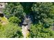 Aerial view of a home surrounded by lush green trees on a sunny day at 2030 Buford Dam Rd, Buford, GA 30518