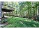 Large backyard with lush green grass and mature trees with a deck overlooking the yard at 2030 Buford Dam Rd, Buford, GA 30518