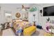 Bright bedroom featuring a floral bedspread, ceiling fan, and arched window for natural light at 2030 Buford Dam Rd, Buford, GA 30518