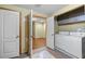Well-equipped laundry room featuring modern washer and dryer appliances, cabinets and access to an adjacent room at 2030 Buford Dam Rd, Buford, GA 30518