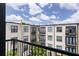 Exterior of building with multiple balconies, neutral colors, black trimmed windows, and greenery under a blue sky at 5300 Peachtree Rd # 3207, Chamblee, GA 30341