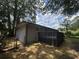 Back of the house with a deck surrounded by large trees, with a small fence at 8236 Tudor Dr, Jonesboro, GA 30238