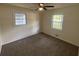 Cozy bedroom features a ceiling fan, neutral walls, and two windows providing natural light and carpeted flooring at 8236 Tudor Dr, Jonesboro, GA 30238