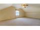 Attic with carpeted floors, ceiling fan, window, and ample natural light at 1216 Valley Dr, Conyers, GA 30012