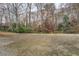 A expansive backyard featuring a concrete patio and a lush canopy of trees at 1216 Valley Dr, Conyers, GA 30012