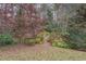 Spacious backyard featuring mature trees and a charming wooden bridge at 1216 Valley Dr, Conyers, GA 30012