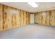 Spacious basement with wood paneled walls, carpet flooring, and a door at 1216 Valley Dr, Conyers, GA 30012