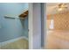 Carpeted bedroom with floral wallpaper, ceiling fan, and an adjacent walk-in closet and bathroom at 1216 Valley Dr, Conyers, GA 30012