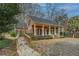 Side view of a brick home featuring a covered porch and lush landscaping at 1216 Valley Dr, Conyers, GA 30012