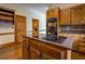 A classic kitchen featuring granite counters, wood cabinets and an island cooktop at 1216 Valley Dr, Conyers, GA 30012