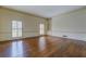 Spacious living room featuring hardwood floors, large windows with shutters, and a built-in bookshelf at 1216 Valley Dr, Conyers, GA 30012
