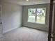 Bedroom with natural light, neutral walls and trim, and a large window overlooking the neighborhood at 305 Melanie Ct, Bowdon, GA 30108