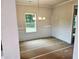 Dining room features decorative trim, a modern chandelier, and a large window with a view of trees and the back yard at 305 Melanie Ct, Bowdon, GA 30108