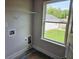 Bright laundry room with window and shelving for efficient organization and storage at 305 Melanie Ct, Bowdon, GA 30108