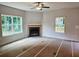 Living room featuring a fireplace, neutral walls and trim, and multiple windows that fill the space with natural light at 305 Melanie Ct, Bowdon, GA 30108