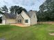 Backyard view of home showcasing landscaped grounds, fenced backyard, and manicured lawn at 521 Deadwood Trl, Locust Grove, GA 30248