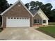 Charming brick and siding home featuring an attached garage and well-maintained front lawn at 521 Deadwood Trl, Locust Grove, GA 30248