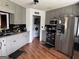 Modern kitchen featuring stainless steel appliances, gray cabinets, and adjacent laundry room at 521 Deadwood Trl, Locust Grove, GA 30248