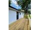 New wooden deck with horizontal railings, black framed door, and white brick exterior walls at 661 Kennesaw Se Dr, Smyrna, GA 30080
