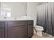 Bathroom with vanity, framed mirror, white towels, and toilet with a shower featuring a stylish curtain at 6345 Mountain Home Se Way, Mableton, GA 30126