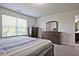 Bedroom with a large window providing natural light, dresser, and access to bathroom at 6345 Mountain Home Se Way, Mableton, GA 30126