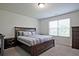 Comfortable bedroom featuring a large bed, side table, and ample natural light from the window at 6345 Mountain Home Se Way, Mableton, GA 30126