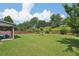 Spacious backyard with lush green lawn, mature trees, and a covered patio, perfect for outdoor enjoyment and entertaining at 852 Van Briggle Path, Sugar Hill, GA 30518