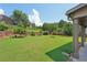 Large, beautifully landscaped backyard featuring mature trees, lush lawn, and plenty of space for outdoor activities and enjoyment at 852 Van Briggle Path, Sugar Hill, GA 30518