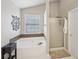 Bathroom featuring a soaking tub with mosaic tile accents and a separate glass-enclosed shower at 852 Van Briggle Path, Sugar Hill, GA 30518
