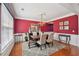 Beautiful dining room boasts red walls, hardwood floors, and a decorative rug beneath the dining table at 852 Van Briggle Path, Sugar Hill, GA 30518