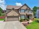 Charming two-story brick home featuring a well-manicured lawn and an attached two-car garage at 852 Van Briggle Path, Sugar Hill, GA 30518