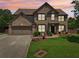 Traditional brick two-story home boasts a well-manicured lawn and attached two-car garage at 852 Van Briggle Path, Sugar Hill, GA 30518