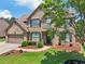 Charming home with brick front, well-maintained lawn, and mature trees, offering a welcoming curb appeal and beautiful setting at 852 Van Briggle Path, Sugar Hill, GA 30518