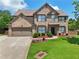 Traditional two-story home with brick facade, manicured lawn, and mature landscaping, offering curb appeal and charm at 852 Van Briggle Path, Sugar Hill, GA 30518