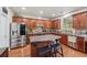 Modern kitchen features stainless steel appliances, granite counters, and an island with barstool seating at 852 Van Briggle Path, Sugar Hill, GA 30518