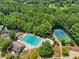 Aerial view of a community pool and tennis courts surrounded by lush green trees at 852 Van Briggle Path, Sugar Hill, GA 30518