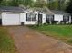 Charming single-story home with a well-manicured lawn and blossoming tree in the front yard at 218 Whispering Pine Circle Ne Cir, White, GA 30184