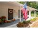 Close-up of a charming front porch with an American flag, a wreath, and white painted brick at 2377 Emory Ln, Marietta, GA 30068