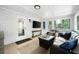 Inviting sunroom features neutral furniture, tile floor, TV and sliding door at 2377 Emory Ln, Marietta, GA 30068